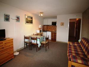 a kitchen and dining room with a table and a couch at Appartement Auris, 1 pièce, 4 personnes - FR-1-297-248 in Auris