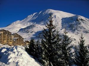 a snow covered mountain in front of a ski lodge at Appartement Auris, 1 pièce, 4 personnes - FR-1-297-248 in Auris