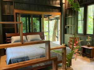a bedroom with a bed in a room with windows at Luboa Hut - Tiny House in Ko Jum