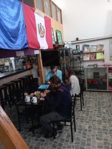 um grupo de pessoas sentadas numa mesa num restaurante em Andes Hostel em Huaraz