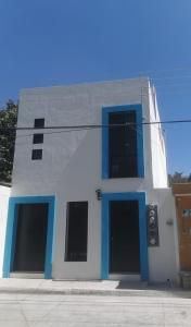 een wit en blauw gebouw met blauwe deuren bij Casa Apolonia in Santa Lucía