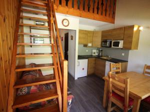 ein Zimmer mit einer Küche und einer Treppe in einem winzigen Haus in der Unterkunft Appartement Auris, 1 pièce, 4 personnes - FR-1-297-298 in Auris
