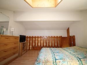 ein Schlafzimmer mit einem Bett, einer Kommode und einem TV in der Unterkunft Appartement Auris, 1 pièce, 4 personnes - FR-1-297-298 in Auris