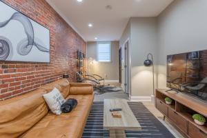 un soggiorno con divano e muro di mattoni di Baltimore's Home Away From Home apts a Baltimora