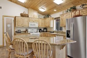 cocina con armarios de madera y nevera de acero inoxidable en 2163-Chalet d'Or home, en Big Bear Lake