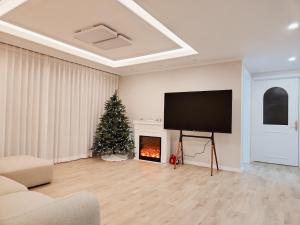 un salon avec un arbre de Noël et une télévision à écran plat dans l'établissement Grand open Hongdae houes 4bdr 2bth, à Séoul