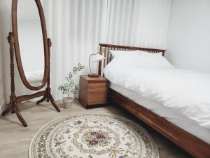 - une chambre avec un lit, un miroir et un tapis dans l'établissement Grand open Hongdae houes 4bdr 2bth, à Séoul
