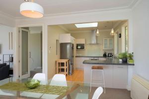 een keuken en een woonkamer met een tafel en stoelen bij Stairway to heaven in Dunedin