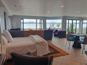 a bedroom with a bed and a view of the water at Aqua On The Beach in Auckland