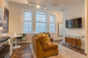 sala de estar con sofá y TV en Inner Harbor's Best Furnished Luxury Apartments apts, en Baltimore