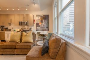 a living room with two couches and a large window at Inner Harbor's Best Furnished Luxury Apartments apts in Baltimore
