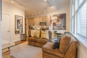 a living room with two chairs and a table and a kitchen at Inner Harbor's Best Furnished Luxury Apartments apts in Baltimore