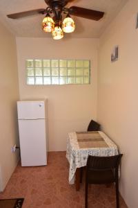 uma cozinha com uma mesa e um frigorífico branco em Harada Inn and Suites em Hopkins