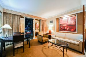 uma sala de estar com um sofá e uma mesa em MGM Signature Towers, Balcony Suite, Strip View - NO RESORT FEES! em Las Vegas