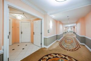a hallway with orange walls and a white door and a rug at MGM Signature Towers, Balcony Suite, Strip View - NO RESORT FEES! in Las Vegas