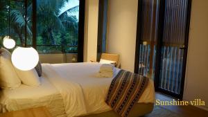 1 dormitorio con cama y ventana grande en Westcoast PQ Sunshine spacious 3BR private pool villa en Phu Quoc