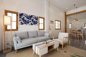 un soggiorno con divano e tavolo di Villa Sunrise Garden B190 a Ban Muang Mai