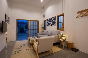 ein Wohnzimmer mit einem Sofa und einem Tisch in der Unterkunft Villa Sunrise Garden B190 in Ban Muang Mai