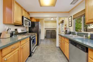 uma grande cozinha com armários de madeira e electrodomésticos de aço inoxidável em 2049-Summit Watch home em Big Bear Lake