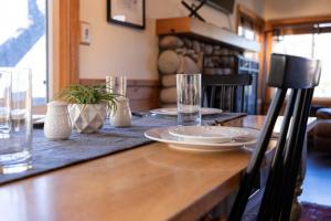 een houten tafel met borden en glazen erop bij 1977- Black Oak Cabin home in Big Bear Lake