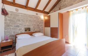 a bedroom with a bed and a stone wall at Stunning Home In Ostrvica With Sauna, Wifi And Outdoor Swimming Pool in Ostrvica