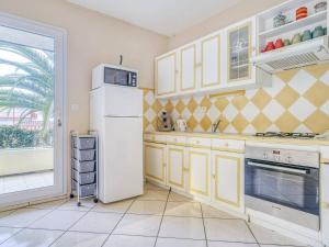 La cuisine est équipée de placards jaunes et d'un réfrigérateur blanc. dans l'établissement Appartement Saint-Jean-de-Luz, 4 pièces, 8 personnes - FR-1-4-499, à Saint-Jean-de-Luz