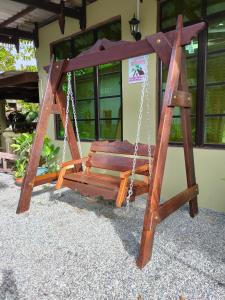 a wooden swing sitting in front of a building at Hidden Homestay in Marang
