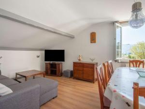 ein Wohnzimmer mit einem Esstisch und einem TV in der Unterkunft Charmant appartement à 15min de St Jean avec jardin - FR-1-4-493 in Urrugne