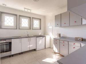 eine Küche mit weißen Schränken und weißen Geräten in der Unterkunft Charmant appartement à 15min de St Jean avec jardin - FR-1-4-493 in Urrugne + 3 Fotos