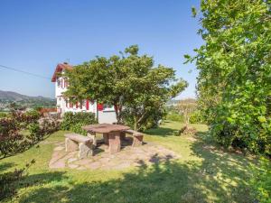 einen Picknicktisch im Hof eines Hauses in der Unterkunft Charmant appartement à 15min de St Jean avec jardin - FR-1-4-493 in Urrugne