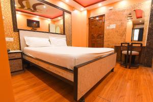 a bedroom with a large bed with a large mirror at FabExpress Wild Orchid in Kolkata