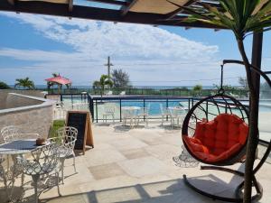 un patio con sedia, tavoli e piscina di Arraial do Cabo. Conforto, Piscina, Vista Mar. ad Arraial do Cabo