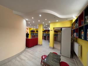 a restaurant with yellow and yellow walls and a table at Hostel Jeal in Batumi