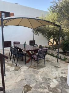 a wooden table and chairs under an umbrella at DROUSHIA CORNER HOUSE in Drousha