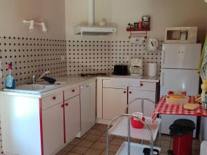 cocina con armarios blancos, fregadero y mesa en Appartement Cauterets, 3 pièces, 6 personnes - FR-1-234-298, en Cauterets