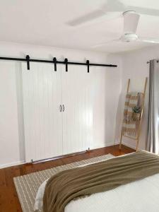 a bedroom with a white closet and a bed at Lammermoor Lodge Holiday Home Yeppoon in Yeppoon