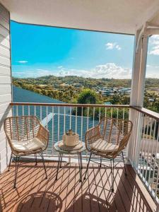 two chairs and a table on a balcony with a view at Lammermoor Lodge Holiday Home Yeppoon in Yeppoon