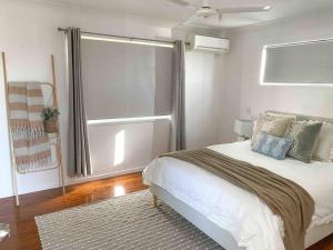 Un dormitorio con una cama grande y una ventana en Lammermoor Lodge Holiday Home Yeppoon, en Yeppoon