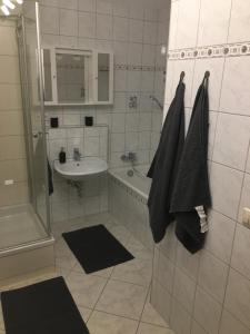 a white bathroom with a sink and a tub and a shower at Ferienwohnung am Goethe Park für 2 bis 3 Personen in Jena