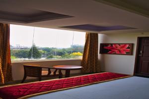 1 dormitorio con cama, mesa y ventana en Business inn, en Bangalore