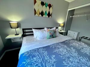 1 dormitorio con 1 cama azul y blanca y 2 lámparas en Canadian Rockies Chalets en Canmore