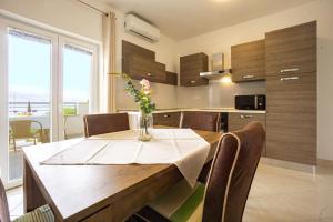 a kitchen and dining room with a table and chairs at Babara beautiful setting right on beach with modern facilities in Metajna