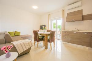a kitchen and living room with a table and a couch at Babara beautiful setting right on beach with modern facilities in Metajna