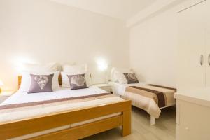 two beds in a room with white walls at Babara beautiful setting right on beach with modern facilities in Metajna