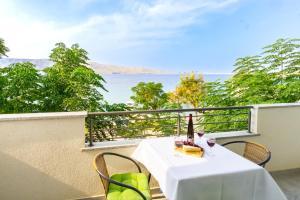 a table with a bottle of wine on a balcony at Babara beautiful setting right on beach with modern facilities in Metajna