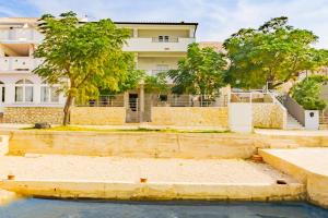 a house with a pool in front of it at Babara beautiful setting right on beach with modern facilities in Metajna +2 photos