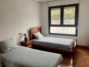 een slaapkamer met 2 bedden en een raam bij Luminosa habitación in Arrasate - Mondragon