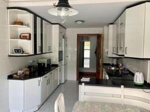 eine Küche mit weißen Schränken und einer schwarzen Arbeitsplatte in der Unterkunft Luminosa habitación in Arrasate - Mondragon
