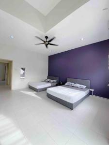 1 Schlafzimmer mit 2 Betten und einer lila Wand in der Unterkunft Niana Homestay Melaka -near town in Malakka