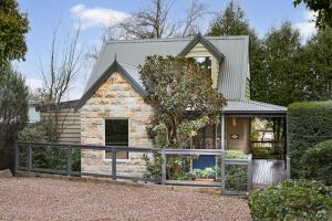 una casa de piedra con techo de metal en Two Truffles Cottage Accommodation, en Yarra Glen